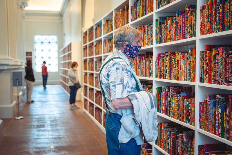 A museum visitor looking at Shonibare's "The American Library"