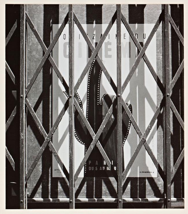 A black and white picture of a poster behind grating
