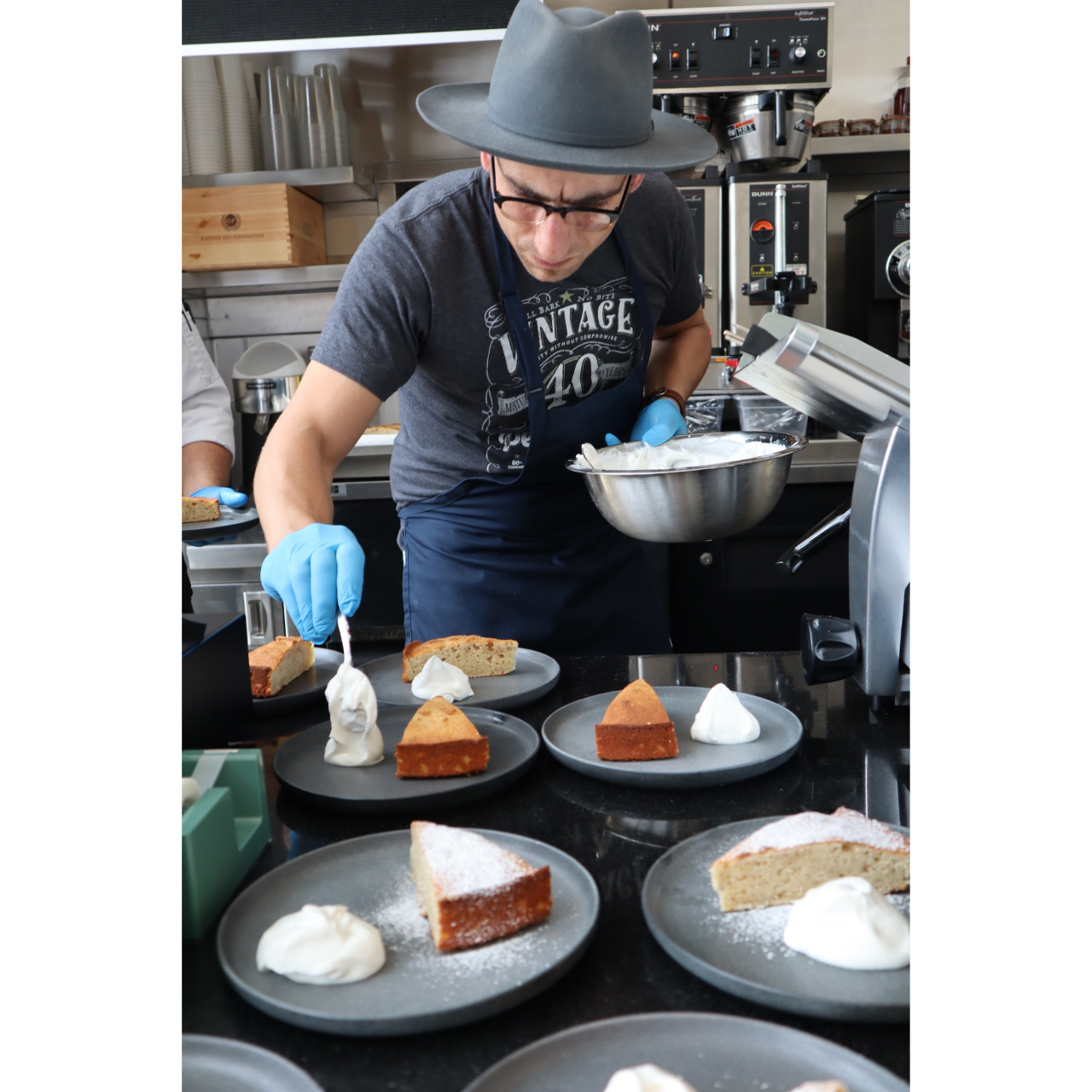 An image of Cantor cafe's chef, Rocco Scordella, puring creme fraiche on an italian cake
