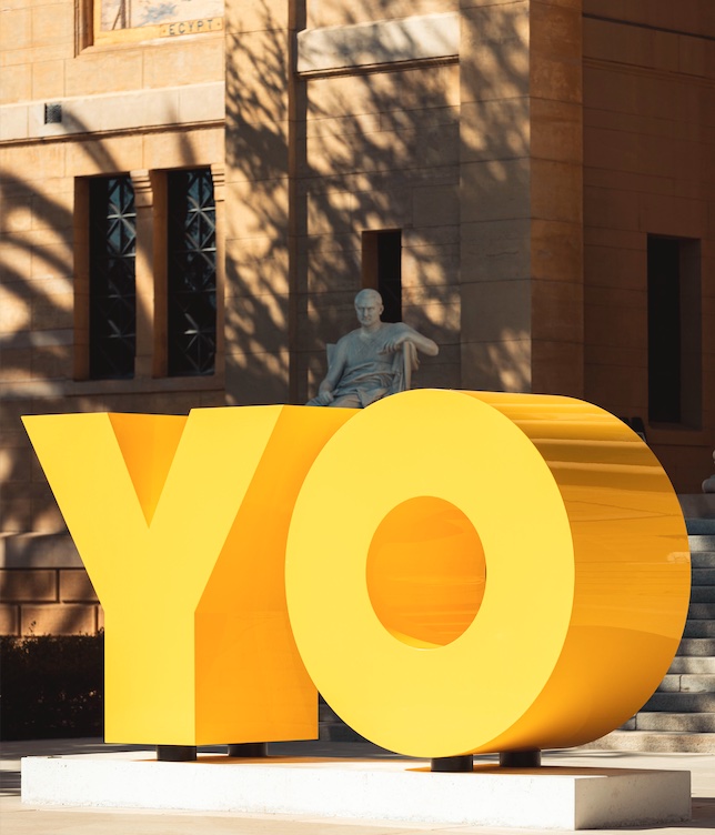 An image of a large format yellow sculpture of a letter Y and a letter O