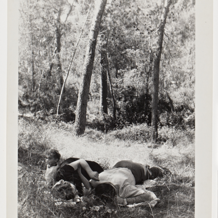 A black and white photograph of a couple with child in the woods