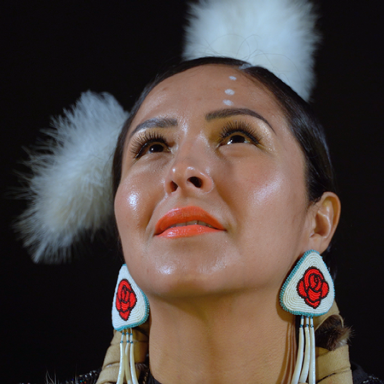 A image of a native american woman looking up with a black background