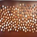 a wall covered in masks made of clay