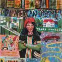 A colorful mixed-media artwork centered on a woman standing with arms crossed, wearing a red hat and a dark green shirt with colorful vertical stripes. Above her head, bold black text reads "AN AMERICAN DREAM" set against a vibrant city skyline under a dark sky. Surrounding her are scenes depicting various aspects of life, including a suburban house with a white fence, a red car on a road, a full shopping cart, a yellow school bus parked outside a brick building with a U.S. flag, and a yellow mountain peak.