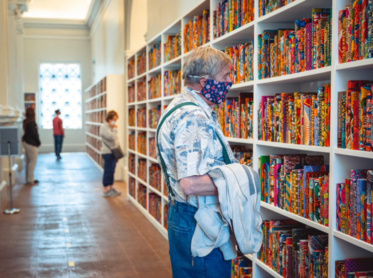 A museum visitor looking at Shonibare's "The American Library"