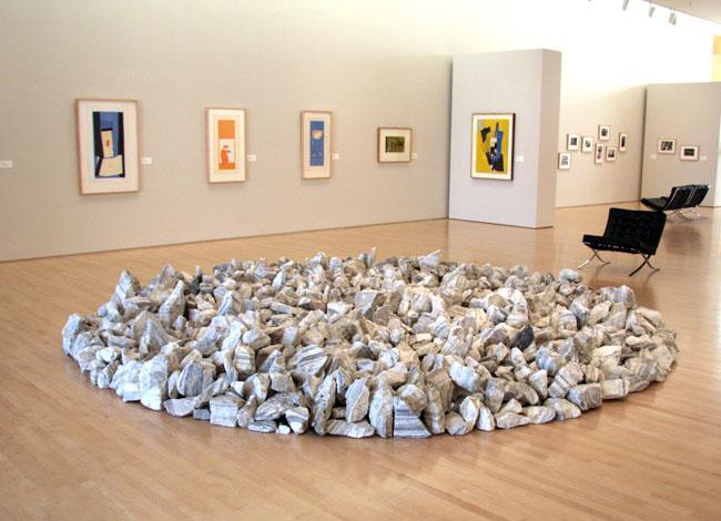 A gallery view depicting the artwork "Georgia Granite Circle," shwing rocks arranged in a circular shape on the ground