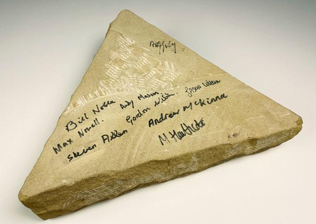 A triangular stone signed by Andy Goldsworthy