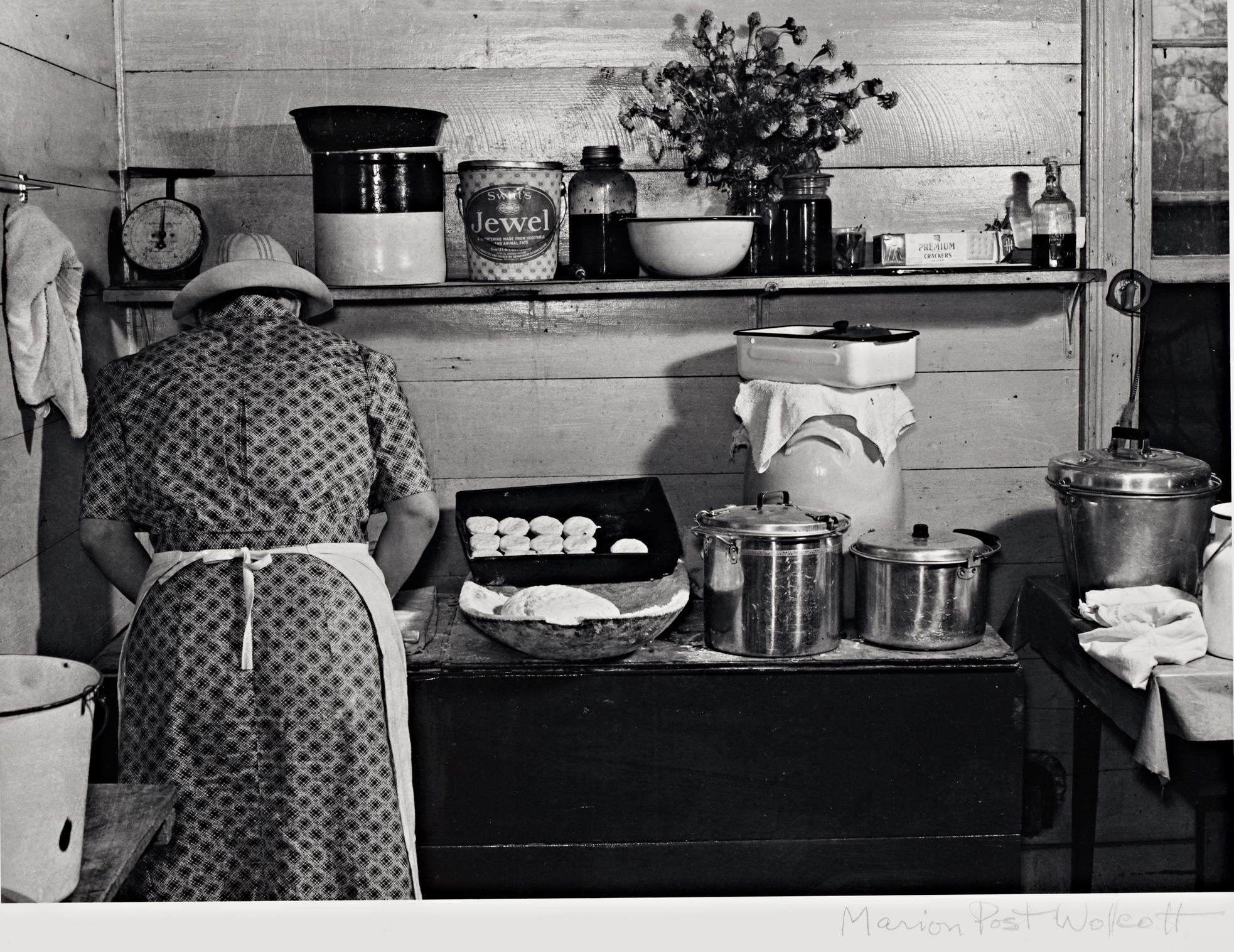 A woman in a kitchen facing away from the viewer