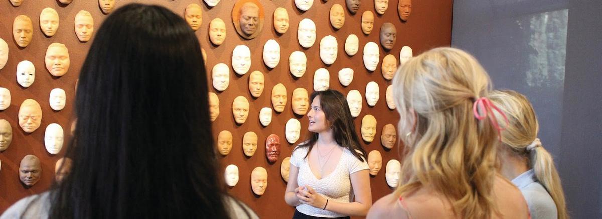 An image of women looking at a wall of masks