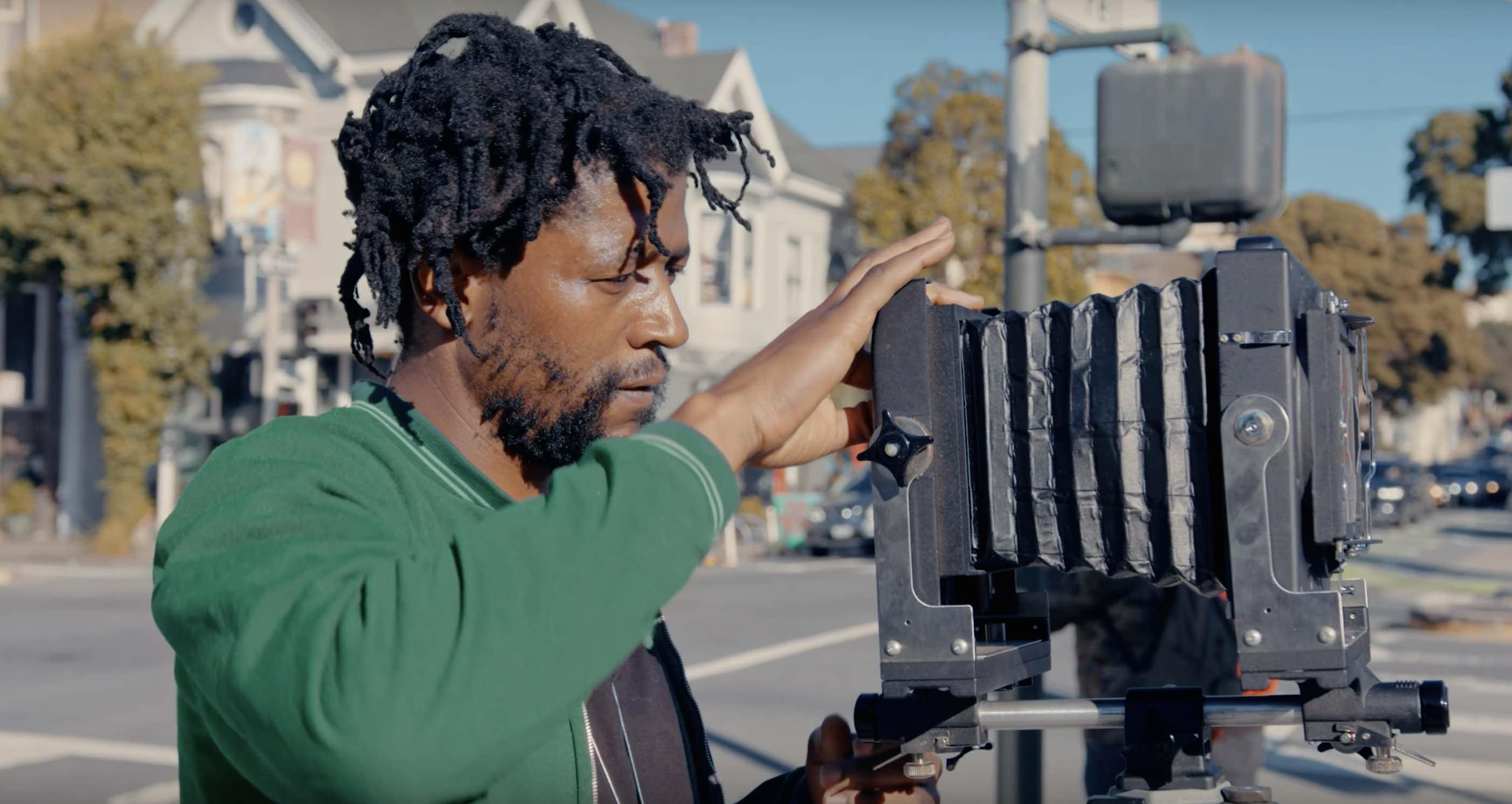 An image of a black man preparing to take a picture on the street