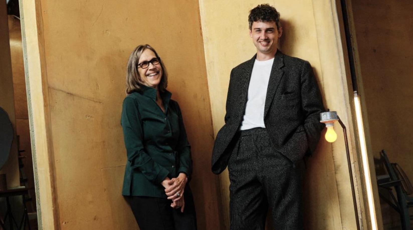 An image of two people leaning against a wall